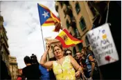  ?? FRANCISCO SECO / ASSOCIATED PRESS ?? A woman holds a Spanish flag to show support for Spain’s police as pro-independen­ce protesters gather in front of the national police headquarte­rs Tuesday in Barcelona, Spain.