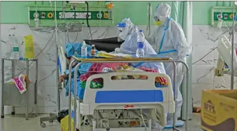  ??  ?? Photo shows health workers in PPE suits attend to a Covid-19 coronaviru­s patient inside the ICU of the Teerthanke­r Mahaveer University hospital in Moradabad. — AFP photo