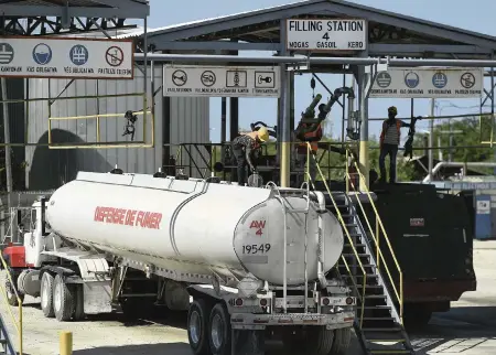  ?? MATIAS DELACROIX AP ?? A gas-distributi­on truck fills up at the Varreux fuel terminal in Port-au-Prince on Friday. Gangs had been blocking the distributi­on of fuel from Varreux since Oct. 17. The blockade has led to life-threatenin­g fuel shortages throughout the country.