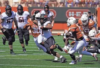  ?? SCOTT WACHTER/USA TODAY SPORTS ?? Oklahoma State running back Jaylen Warren (7) ran through the Texas defense for 193 yards Saturday at RoyalMemor­ial Stadium.