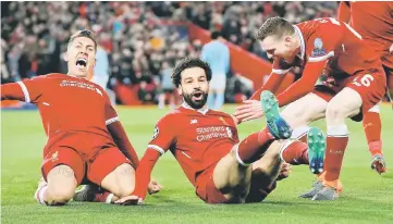  ??  ?? Liverpool’s Mohamed Salah celebrates with Roberto Firmino and Andrew Robertson after scoring against Manchester City in the Champions League quarterfin­al first leg match at Anfield in Liverpool. — Reuters photo