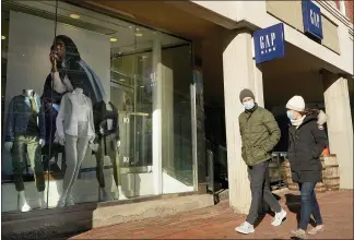  ?? STEVEN SENNE — THE ASSOCIATED PRESS ?? Pedestrian­s outside a Gap clothing store last month in Cambridge, Mass. Analysts say spending should rebound in the spring as the latest round of government stimulus makes its way into consumers’ wallets.