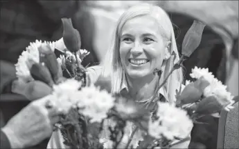  ?? Herald photo by Ian Martens ?? Brandie Lea distribute­s flowers among the audience to be passed forward to others following her presentati­on on philanthro­py during the Southern Alberta Council on Public Affairs on Thursday. @IMartensHe­rald