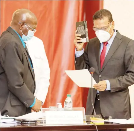  ?? (DPI photo) ?? New Speaker Manzoor Nadir (right) taking the oath of office before Clerk Sherlock Isaacs.