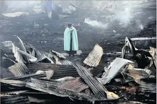  ??  ?? Nomsa Ncube lost everything when her shack burnt down at the Mangolongo­lo squatter camp. A police helicopter flies low and scatters a crowd of foreigners at the Kya Sands squatter camp in June 2008. A standoff had developed between immigrants and a...