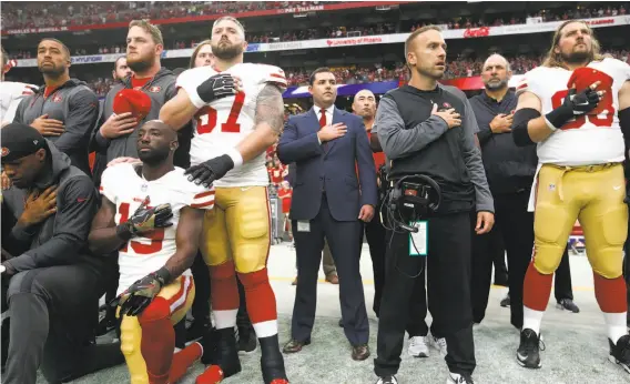  ?? Michael Zagaris / Getty Images ?? CEO Jed York (center) stands with his team in solidarity during the anthem prior to a game against the Cardinals at University of Phoenix Stadium.