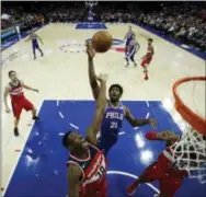  ?? MATT SLOCUM — THE ASSOCIATED PRESS ?? Sixers center Joel Embiid and the Washington Wizards’ Ian Mahinmi, left, go up for a rebound early on Wednesday night in a game between the teams at Wells Fargo Center.