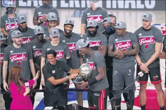  ?? MARK J. TERRILL — THE ASSOCIATED PRESS ?? Miami Heat head coach Erik Spoelstra, center left, hands the Eastern Conference trophy to Bam Adebayo as they celebrate their NBA conference final playoff win over the Celtics Sunday in Lake Buena Vista, Fla.