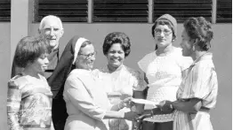  ?? GLEANER ARCHIVES PHOTO ?? In this 1977 photograph, Kay Booker,president of the St Catherine High School Past Students’ Associatio­n, presents a cheque for $1,000 to the principal of the school, Sister Mary Paschal.