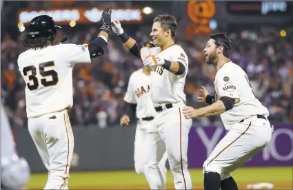  ?? JOSIE LEPE/ STAFF PHOTOS ?? Joe Panik, center, is congratula­ted by Brandon Crawford ( 35), Brandon Belt, right, and other Giants after Panik’s sacrifice fly won it in the ninth.