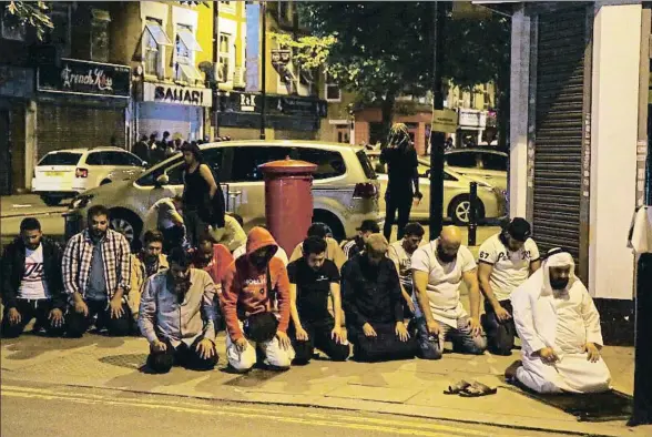  ?? DANIEL LEAL-OLIVAS / AFP ?? Un grupo de hombres musulmanes rezan en una acera del área de Finsbury Park, donde sucedió el ataque