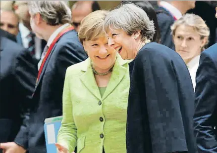  ?? FRANÇOIS LENOIR / REUTERS ?? Angela Merkel y Theresa May, en un momento distendido antes de la cumbre