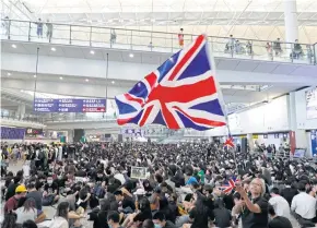  ?? AP ?? A woman waves a British flag during a demonstrat­ion at Hong Kong airport on Friday.