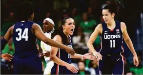  ?? Michael Caterina / Associated Press ?? UConn’s Nika Mühl, center, celebrates with Lou Lopez Sénéchal (11) and Ayanna Patterson (34) react during Sunday’s game at Notre Dame.