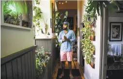  ?? SALWAN GEORGES THE WASHINGTON POST ?? Hilton Carter, 37, has always enjoyed plants. But his Baltimore apartment now holds 180, and it’s a perfect example of a growing trend.