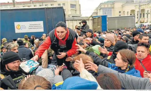  ?? OLEG PETRASYUK / EFE ?? Ucranianos reciben ayuda humanitari­a en Jerson.