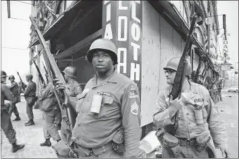  ?? MARTY LEDERHANDL­ER — THE ASSOCIATED PRESS FILE ?? In this file photo, National Guardsmen stand at the corner of Springfiel­d Avenue and Mercer Street in Newark, N.J., where four days of deadly violence and looting came to be known as the Newark riots.