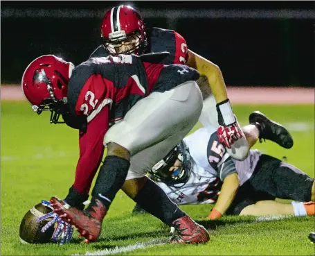  ?? SARAH GORDON/THE DAY ?? Fitch’s Hollis Scott (22) scoops up a fumble by Montville quarterbac­k Luke Hall (15) that was caused by Zach Letellier (13) and returns it for a touchdown during the Falcons’ 28-6 win over the Indians on Friday night in Groton. Visit www.theday.com to...