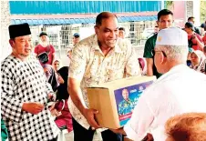  ?? — Bernama photo ?? Ramanan presents a food basket to a recipient.