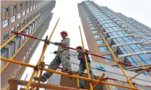  ?? — AFP ?? Constructi­on workers assemble scaffoldin­g on a housing complex in Beijing.
