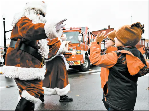  ?? KYLE TELECHAN/POST-TRIBUNE PHOTOS ?? Santa and Mrs. Claus wave to children as they arrive Saturday at Crown Point’s Courthouse Square.