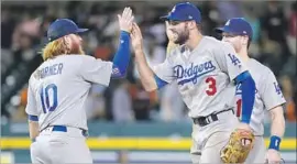  ?? Paul Sancya Associated Press ?? WITH WIN No. 86 in the books, Justin Turner, left, and Chris Taylor get into high-five mode. Taylor, who has flourished as a leadoff hitter, had four hits Friday.