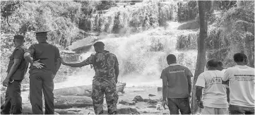  ??  ?? Police and volunteers stand in front of the Waterfalls in Kintampo where 20 students lost their life in an accident a day before. — AFP photo