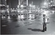  ?? DITA ALANGKARA AP ?? A traffic police officer stands on an empty street at Hotel Indonesia Roundabout, which is normally crowded with people on New Year’s Eve, in Jakarta, Indonesia. To prevent the spread of the virus that causes COVID-19, Indonesia’s government banned events that could attract crowds.