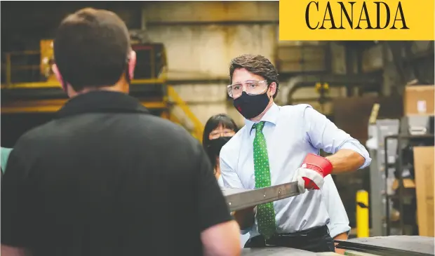 ?? NATHAN DENETTE / THE CANADIAN PRESS ?? Liberal Leader Justin Trudeau works with a piece of steel during a campaign stop at a sheet-metal business in Cambridge, Ont., on Sunday where
he later announced green incentives to help combat climate change. The event was delayed more than an hour by protesters.