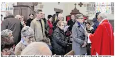  ??  ?? Pendant la procession de la Saint Blaise, le père Lefort impose les deux cierges croisés sur la gorge des fidèles,fidèles en rituel comme souvenir des deux petites lumières.