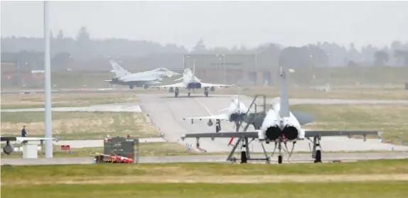  ??  ?? RAF Typhoon jets line up for take-off on a runway at RAF Lossiemout­h in Scotland, on Friday. — Reuters