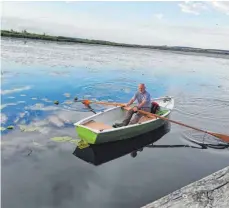  ?? FOTO: TOURIST INFORMATIO­N ?? Peter Vögele im Fischerboo­t auf dem Federsee.