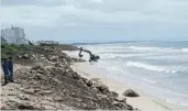  ?? ?? DISAPPEARI­NG BEACH: A front loader piles rocks beneath homes and streets on the edge of St Francis Bay to provide a bulwark for when spring high tides surge across the eroding beach