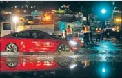  ?? K.C. Alfred San Diego Union-Tribune ?? A CAR drives on Tenth Avenue after one of two water mains burst nearby in San Diego on Sunday.