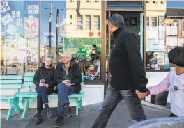  ??  ?? Left: A couple sit on a bench outside Toy Boat Dessert Cafe in the Richmond. Casual dining places are doing better than full-service restaurant­s.