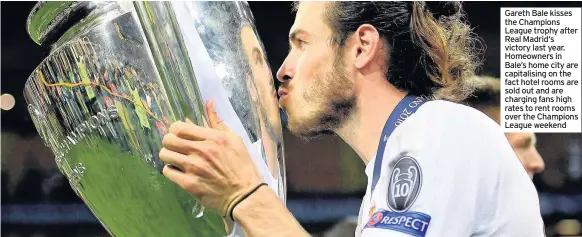  ??  ?? Gareth Bale kisses the Champions League trophy after Real Madrid‘s victory last year. Homeowners in Bale’s home city are capitalisi­ng on the fact hotel rooms are sold out and are charging fans high rates to rent rooms over the Champions League weekend