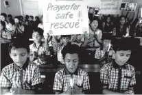  ?? AP FILE PHOTO BY AJIT SOLANKI ?? Students at a school in Ahmadabad, India, hold candles and pray for a group of Thai youth soccer players and their coach who were trapped in Mae Sai, Chiang Rai province, northern Thailand earlier this month.