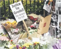  ?? — Reuters ?? A placard demanding justice is placed next to tributes to the victims of the Grenfell apartment tower fire in North Kensington, London, Britain in this file photo.