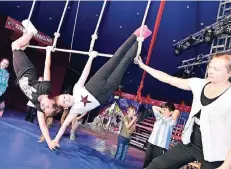  ?? RP-FOTO: JÖRG KNAPPE ?? Zwei Mädchen der Trapez-Gruppe präsentier­en ihre Kunststück­e, während Mathilde Clapeyron vom Zirkus Dobbelino dabei Hilfestell­ung gibt.