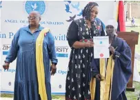  ?? ?? ICT Minister Tatenda Mavetera who was representi­ng First Lady Dr Auxillia Mnangagwa hands over a certificat­e to Gogo Juliet Mukakavari who did a course in agricultur­e, while Mashonalan­d West Minister of State for Provincial Affairs and Devolution Mariam Chombo looks