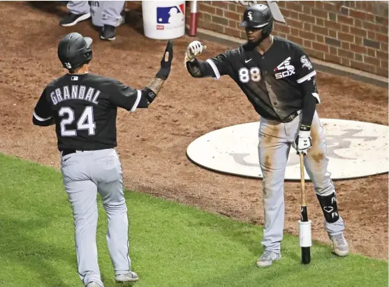  ?? GETTY IMAGES ?? Yasmani Grandal is congratula­ted by Luis Robert after scoring in the Sox’ six-run fifth inning during an exhibition game Sunday against the Cubs at Wrigley Field.