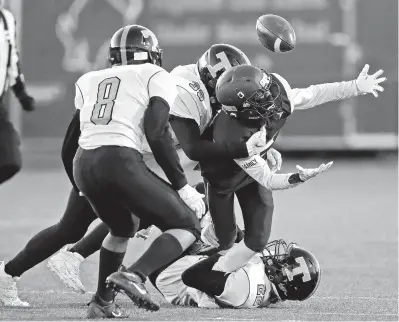  ?? JONATHON GRUENKE/STAFF ?? Poquoson’s Karon Smith loses control of the ball while being hit by Tabb’s Tanner Wells, center, and Chad Seider, bottom, during the Tigers’ 27-0 road victory Friday night. The officials ruled Smith down on the play.