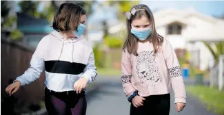  ?? Photo / Dean Purcell ?? Megan Purcell, 8, and Zara Nicholas, 8, wearing their Covid-19 masks as they go for a walk in West Harbour, Auckland, on Thursday.