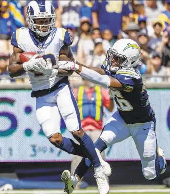  ?? Photograph­s by Robert Gauthier Los Angeles Times ?? BRANDIN COOKS hauls in a 17-yard pass over Chargers cornerback Casey Hayward, landing at the one-yard line and setting up the Rams’ first touchdown. The Rams ran up a season-high 521 yards.