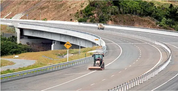  ?? ROSS GIBLIN/STUFF ?? Left, a road sweeper working on Transmissi­on Gully near the Te Ara a Toa bridge. The motorway is finally expected to open by the end of March..