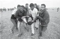  ?? Associated Press ?? ■ Palestinia­n protesters evacuate a wounded youth Friday during clashes with Israeli troops along the Gaza Strip border with Israel, east of Khan Younis, Gaza Strip.