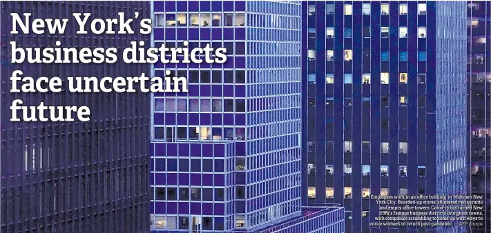  ?? — AFP photos ?? Employees work in an office building in Midtown New York City. Boarded-up stores, shu ered restaurant­s and empty office towers: Covid-19 has turned New York’s famous business districts into ghost towns, with companies scrambling to come up with ways to entice workers to return post-pandemic.