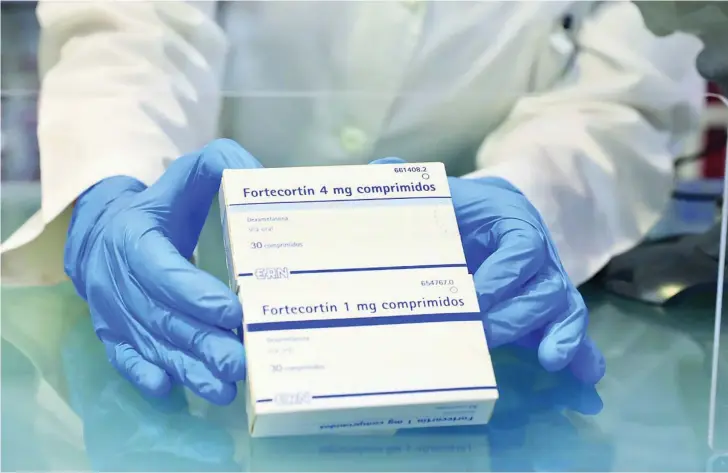 ?? CRISTINA BEJARANO ?? Un profesiona­l farmacéuti­co de Madrid muestra unas cajas de Fortecorti­n, un medicament­o que contiene dexametaso­na, desaconsej­ado para pacientes leves y, desde luego, para personas sanas