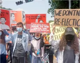  ?? SAI AUNG MAIN/AGENCE FRANCE-PRESSE ?? PROTESTERS hold signs as they take part in a demonstrat­ion against the military coup in front of the Indonesian embassy in Yangon.