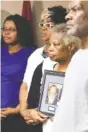  ?? STAFF PHOTO BY ERIN O. SMITH ?? Linda Bonner holds onto a photo of her late husband, Franklin Augustus “Kookie” Bonner, while surrounded by her granddaugh­ter Ciera Wilkes, daughter Stephanie Penson and son Preston Bonner during a news conference at the Newell Towers Tuesday.